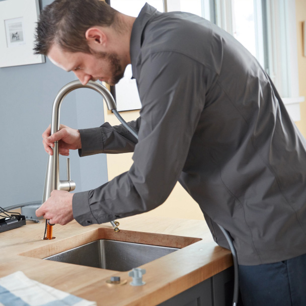 Plumber installing a faucet